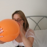 Wench in stockings blowing up balloons